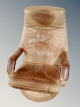 A Scandinavian tan leather swivel armchair