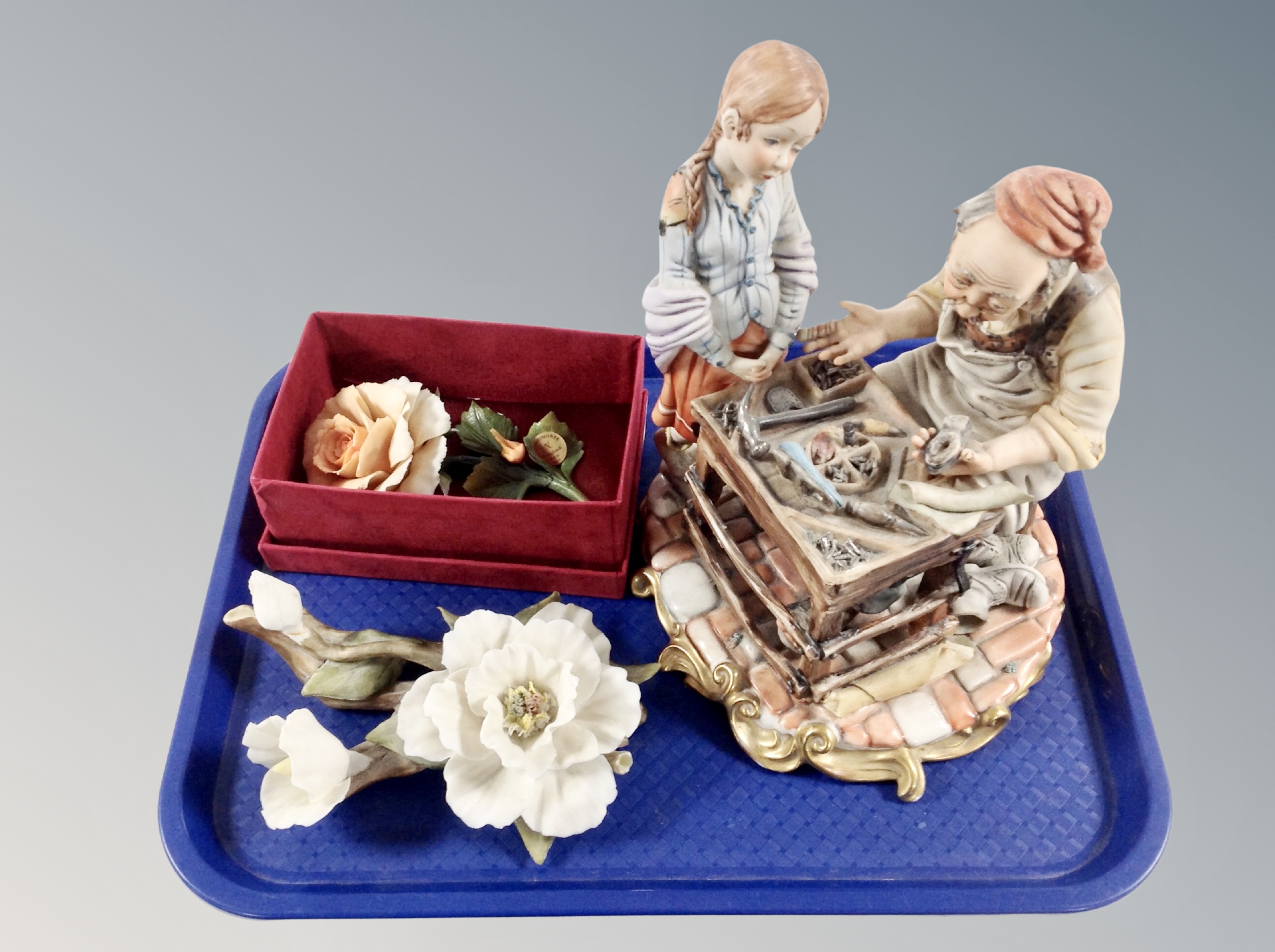 An Italian bisque porcelain figure group depicting a cobbler and a girl together with two