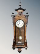 A walnut cased Vienna wall clock with enamelled dial