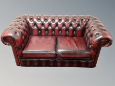 A Chesterfield oxblood buttoned leather two seater settee