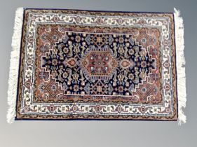 A small fringed Iranian hearth rug 98 cm x 62 cm