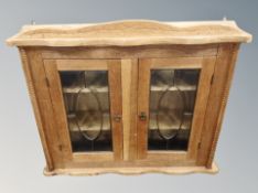 A blond oak double door wall cabinet,