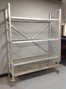 An aluminium four tier trolley / shelf on castors,