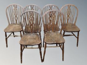 An oak drop leaf dining table together with a set of six wheel backed chairs