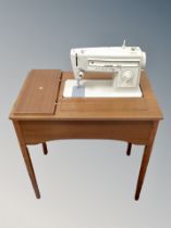 A Singer 507 sewing machine in teak table