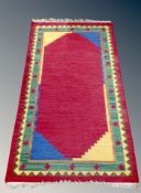 An Eastern flatweave rug on red ground 164 cm x 90 cm