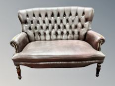 A Chesterfield oxblood buttoned leather two seater settee
