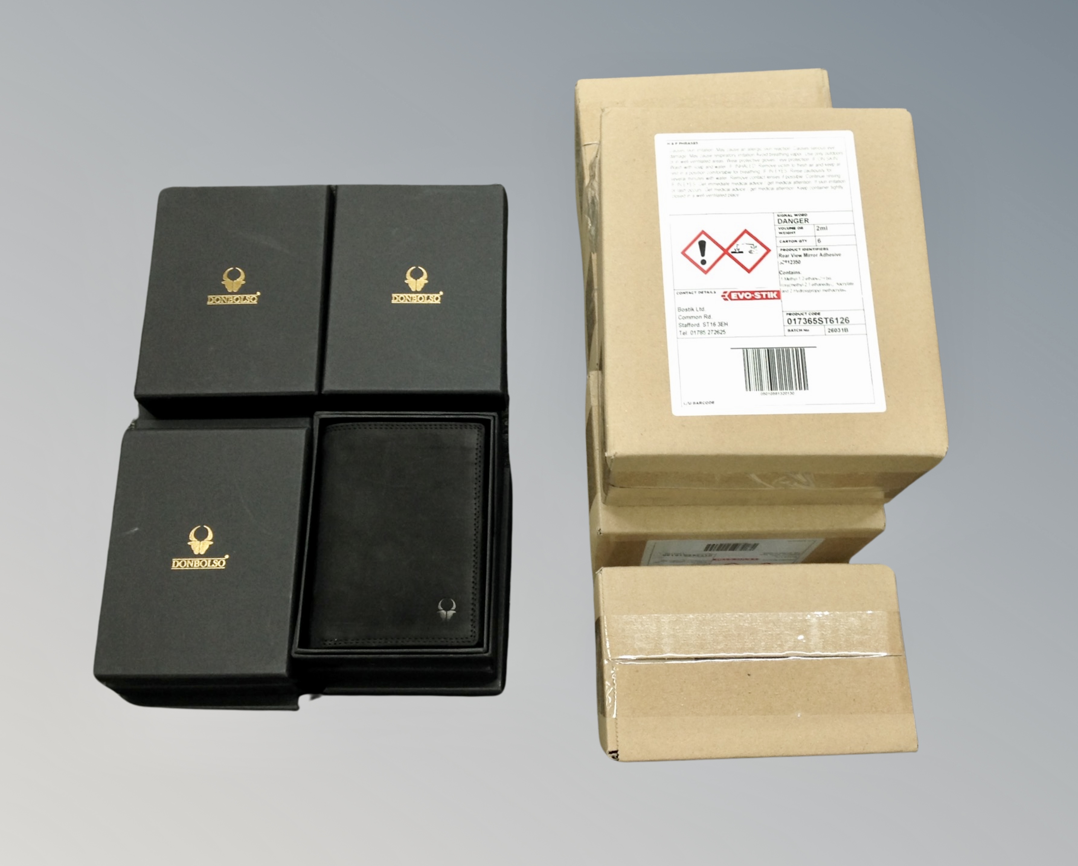 A box of twelve Dombolso leather wallets together with five boxes of Evo Stick rear view mirror
