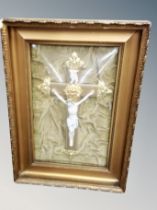 A metal and ceramic crucifix in gilt frame,