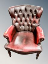 A Chesterfield oxblood buttoned leather armchair