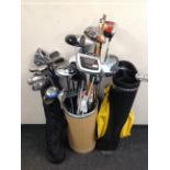 Two golf bags and stick stand containing irons and drivers,