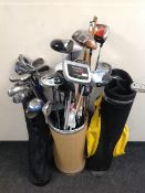 Two golf bags and stick stand containing irons and drivers,