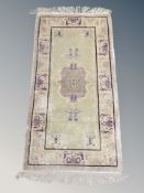 A Chinese fringed rug 140 cm x 63 cm
