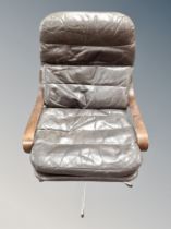 A Scandinavian brown leather beech and chrome swivel armchair