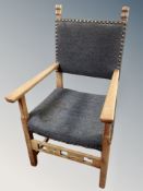 An oak framed armchair in studded grey upholstery