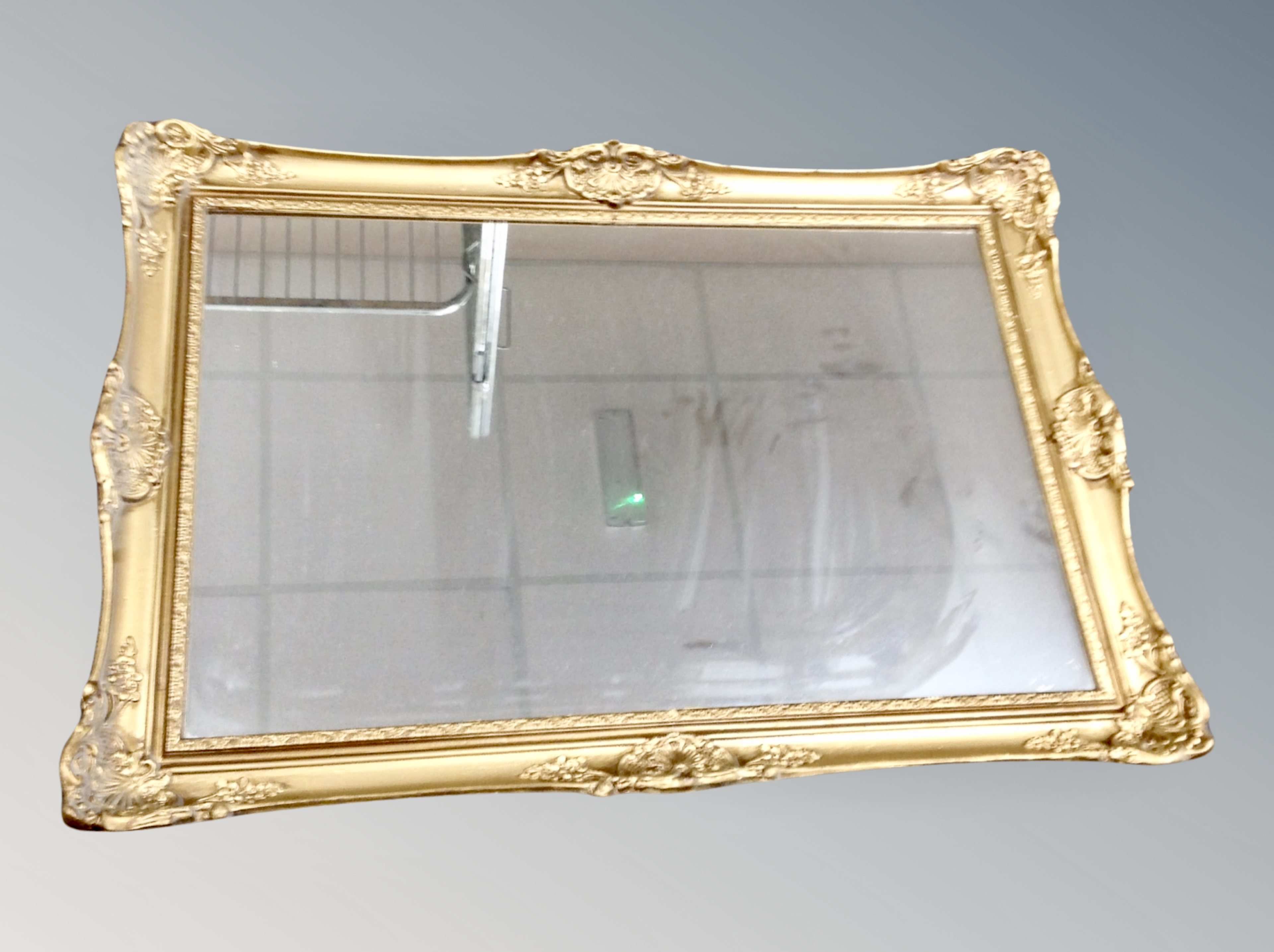 A gilt framed mirror together with a mirrored table lamp