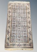 A fringed Iranian rug on pale blue ground 148 cm x 74 cm