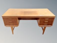 A Danish teak writing desk fitted with six drawers,