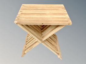 A teak garden X-framed table