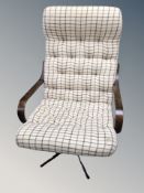 A Scandinavian beech framed swivel armchair in checkered fabric