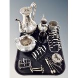 A silver plated three piece tea service, three toast racks, knife rests,