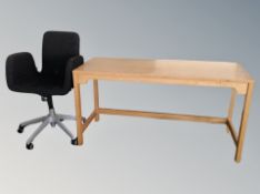 An oak office table together with three swivel chairs