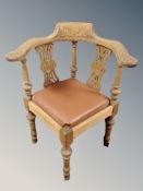 A heavily carved oak corner armchair