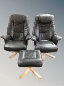 A pair of black leather swivel armchairs with matching footstool