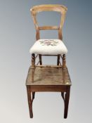 An antique oak school desk together with a chair with tapestry seat
