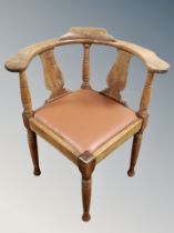 A carved oak corner armchair