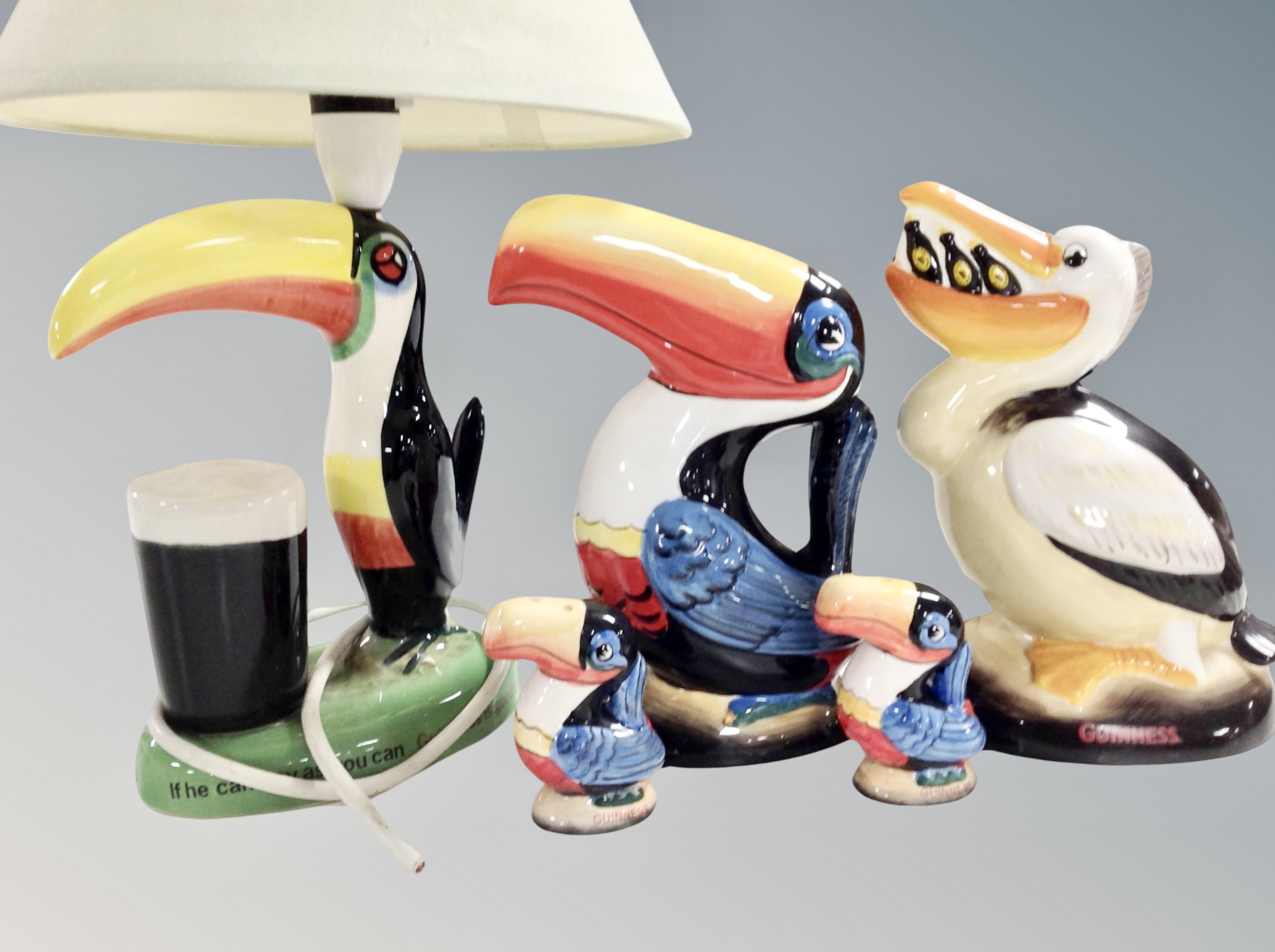 Two Guinness Toucan money boxes, similar pair of salt and pepper sifters,