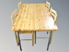 A contemporary pine dining table and four chairs with rattan seats