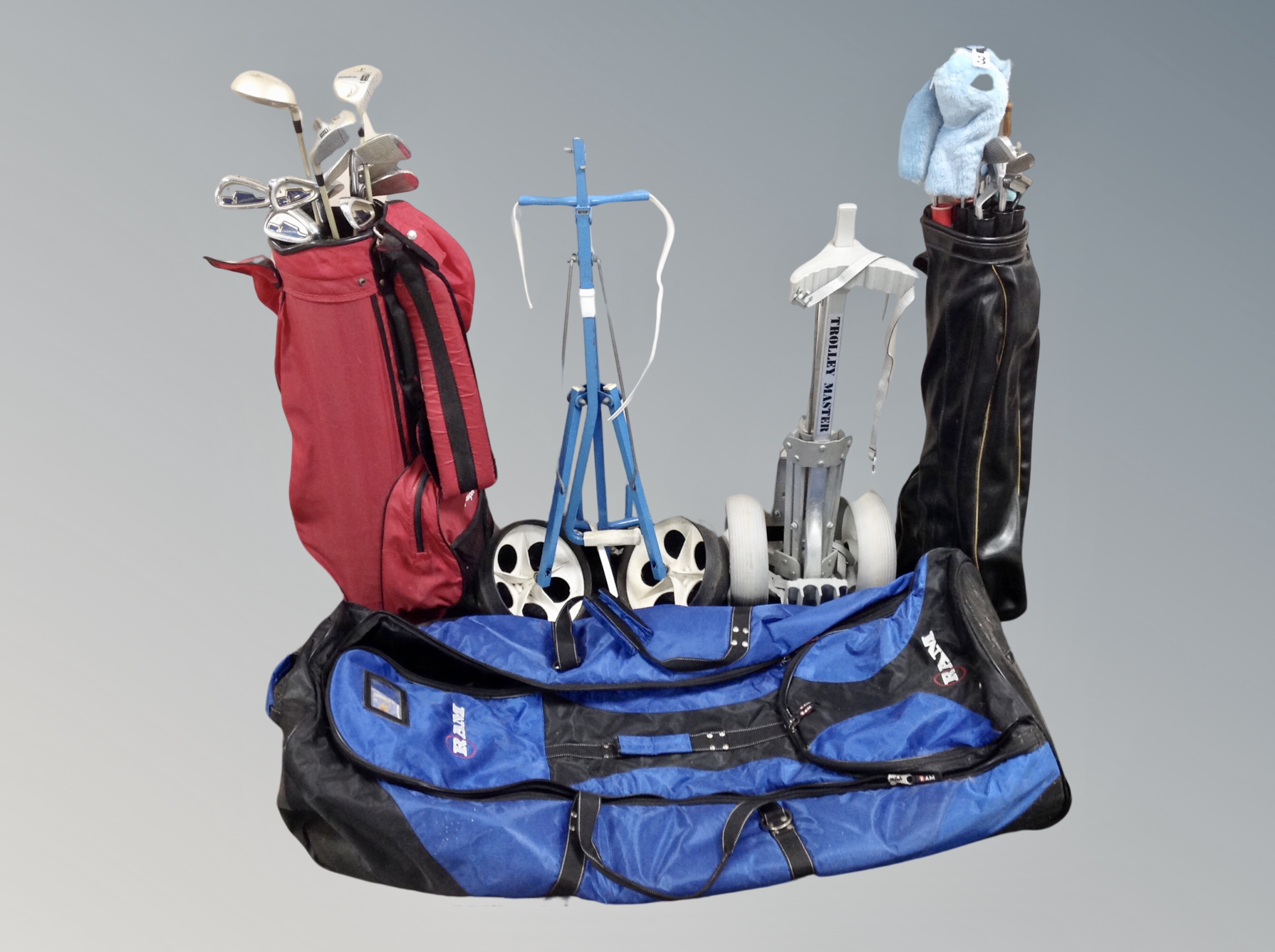 Two folding golf trolleys together with two bags of irons and drivers,