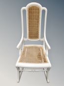 A painted rocking chair with rattan seat