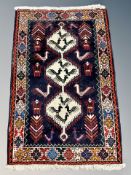 A Caucasian/Anatolian rug with stylised birds on an indigo field of three stepped medallions,