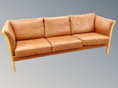 A late 20th century Danish tan leather three seater settee in beech frame,