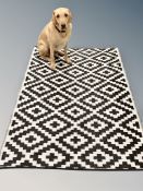 A black and white synthetic kitchen floor mat 121 cm x 184 cm