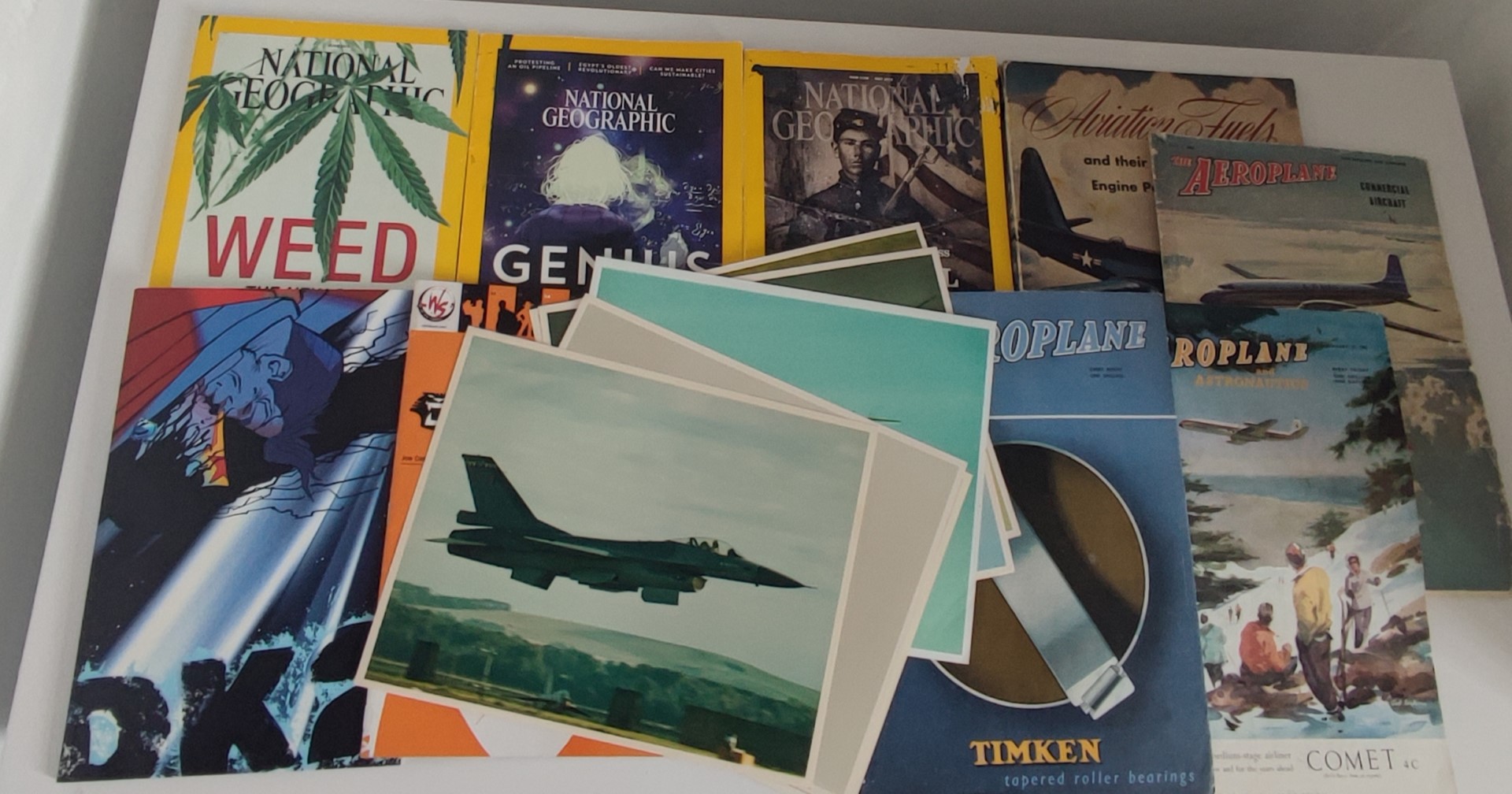 A collection of aviation magazines dating from the 40's and 50's, comics, National Geographic books,