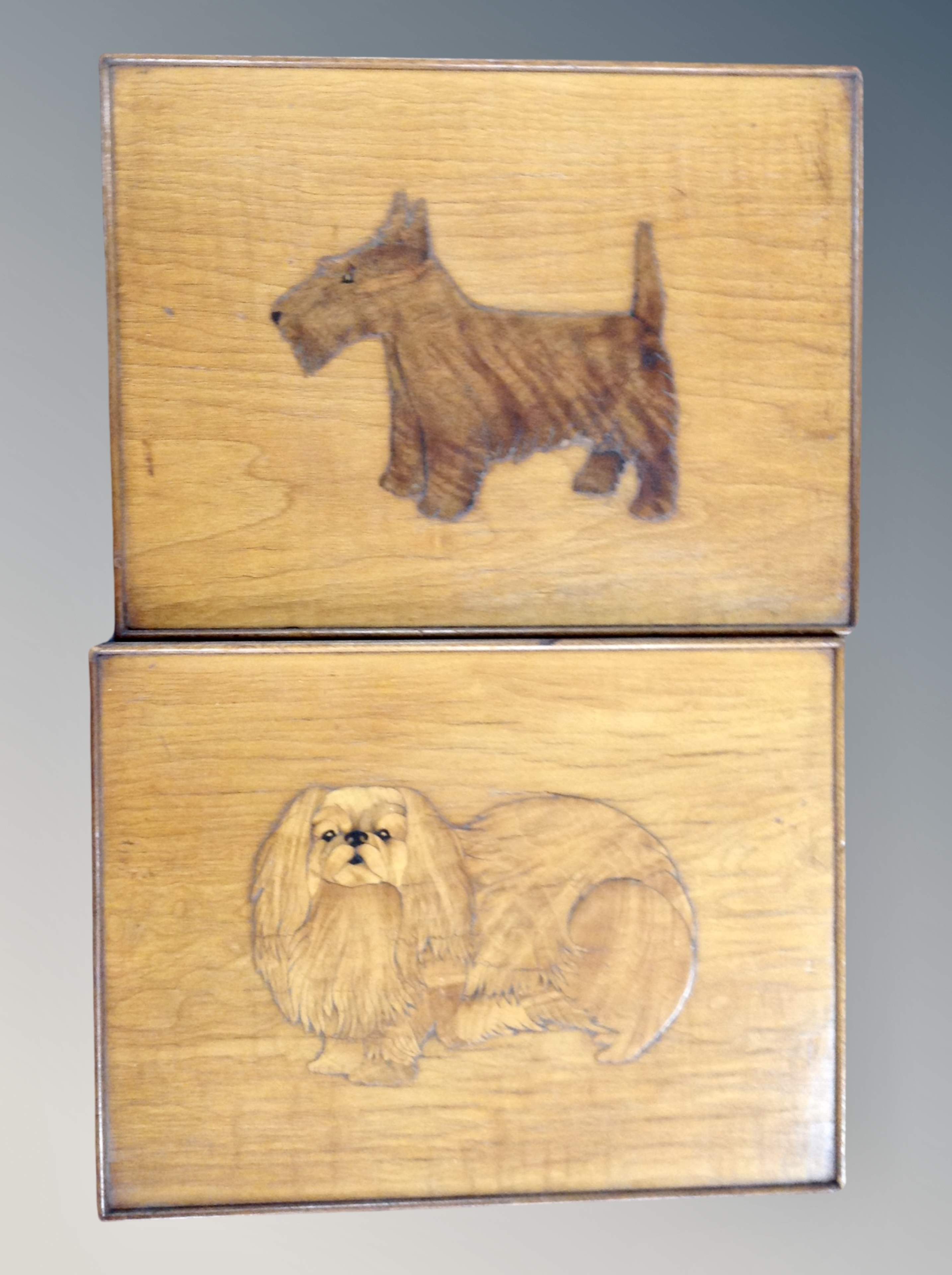 Two wooden plaques depicting dogs,