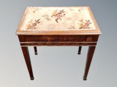 A storage footstool with needlework top