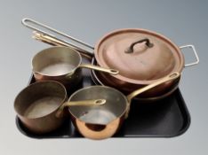 A group of copper and brass cooking pans,