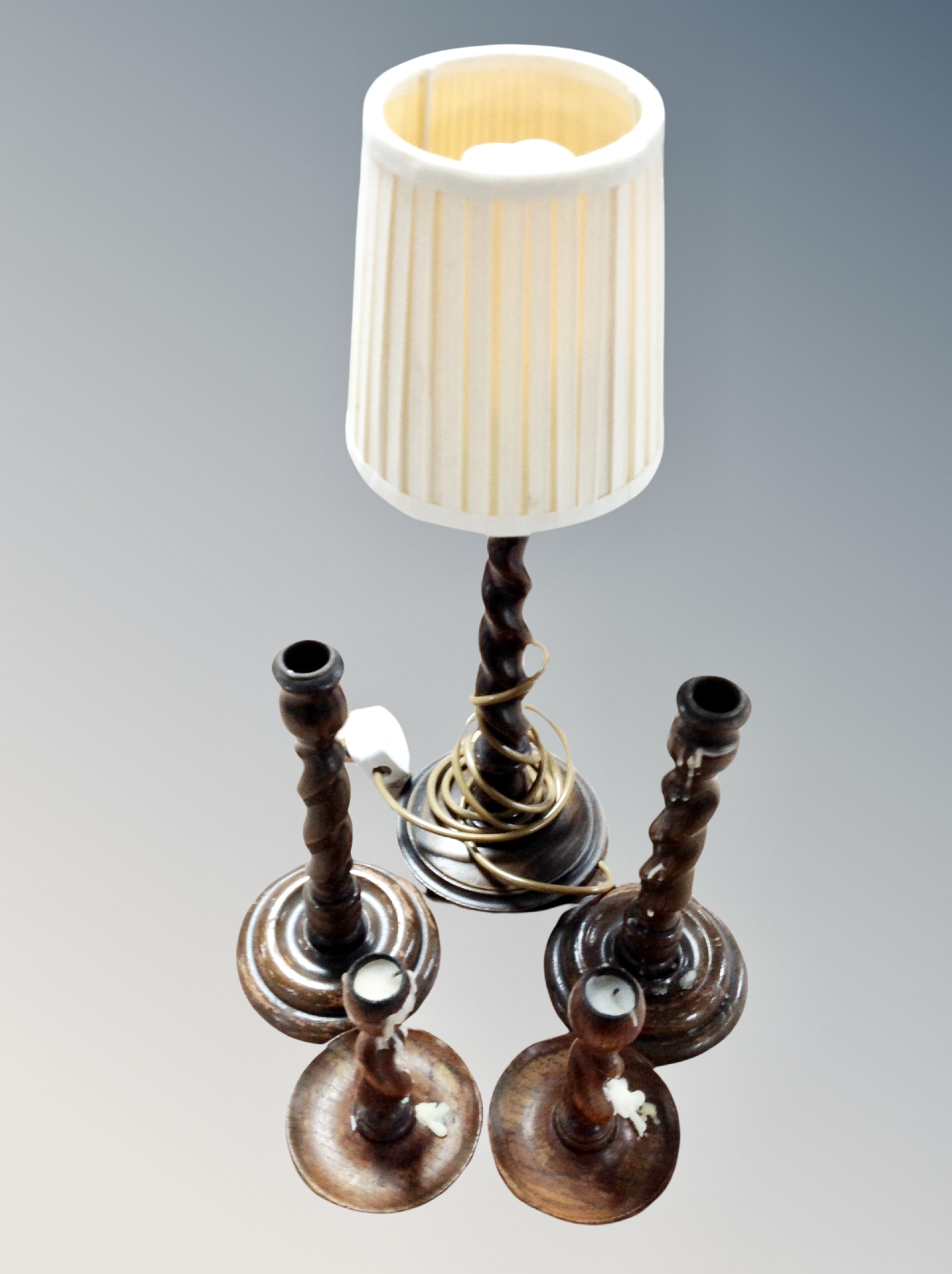 Two pairs of oak barley twist candlesticks and similar table lamp