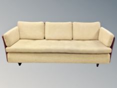 A Scandinavian three seater settee with caned sides and back rest in buttoned sand coloured fabric,