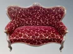 A late 19th century carved two seater salon settee in floral Burgundy fabric,