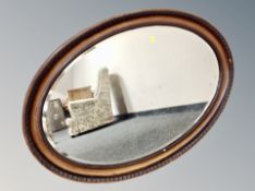 An Edwardian oval mahogany mirror,