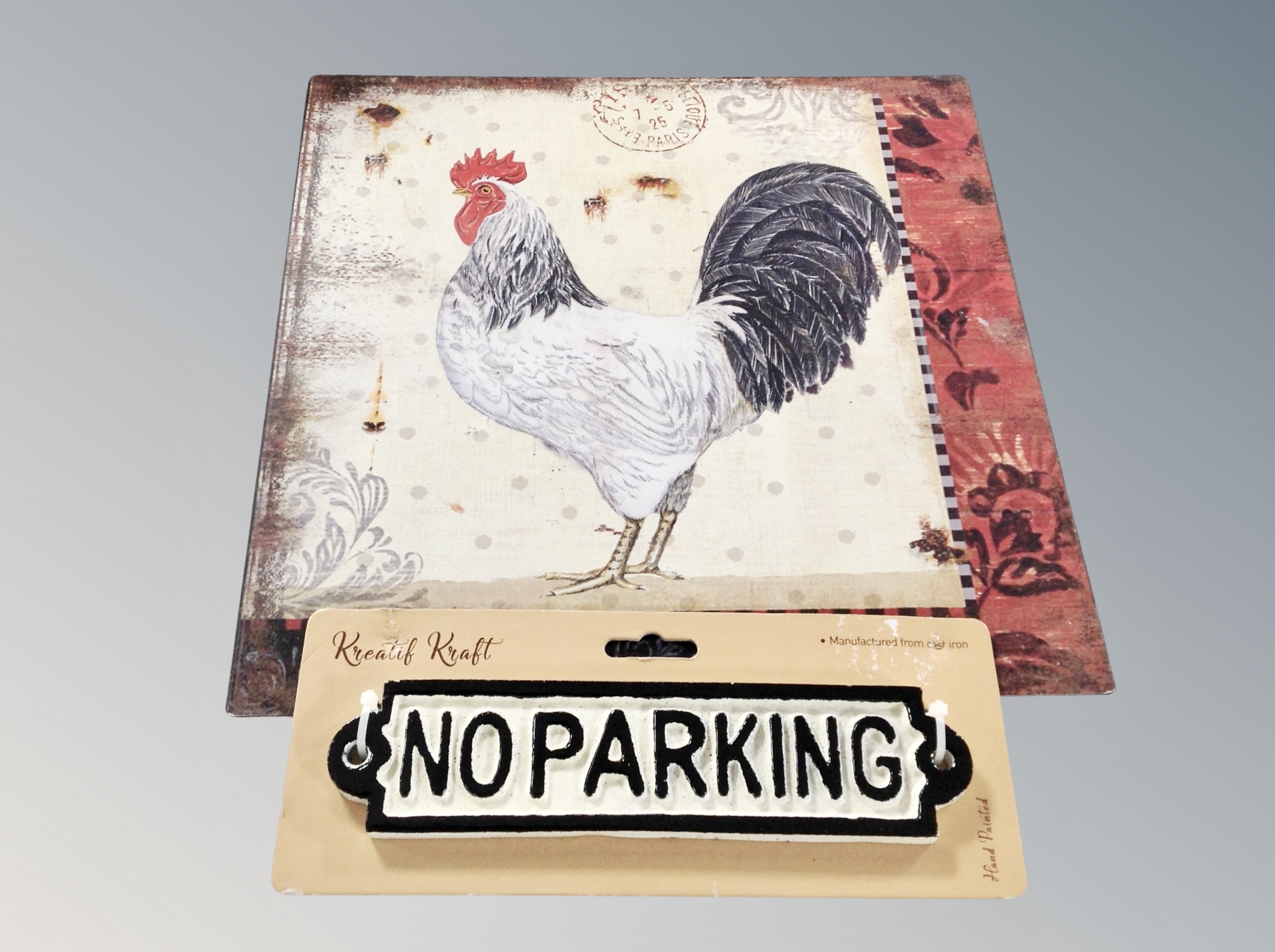 A contemporary no parking sign and a tin sign depicting a cockerel