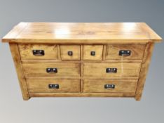 A contemporary stained oak sideboard fitted with eight drawers,