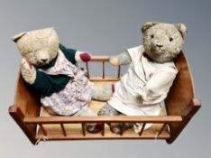 A dolls crib containing two vintage jointed teddy bears