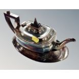 A silver plated teapot on similar stand