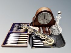 An eight day mantel clock with silvered dial, crystal decanter, horse brasses,